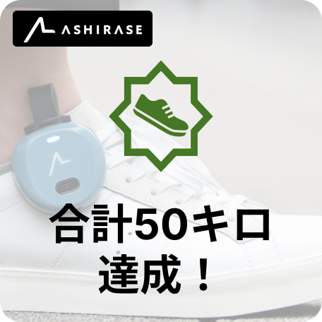 あしらせでナビゲーションで合計５０キロ移移動を達成したことを表すバッジ。靴に取り付けられたデバイスが映っている。